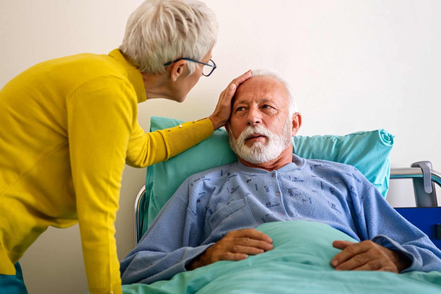 woman caring for man in hospital bed